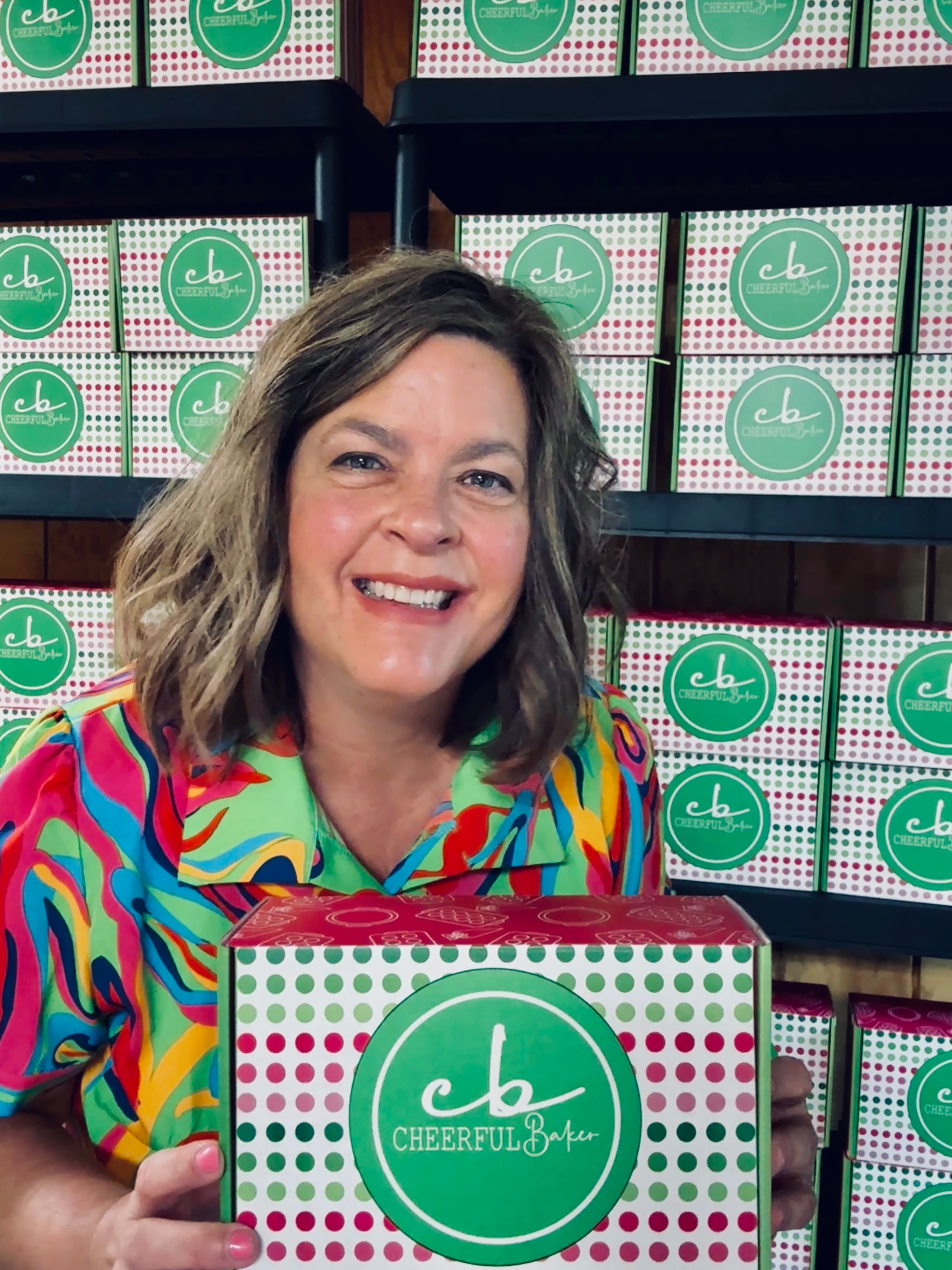 The Cheerful Baker holding a cookie cutter subscription box