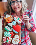 Load image into Gallery viewer, The Cheerful Baker holding Christmas cookies
