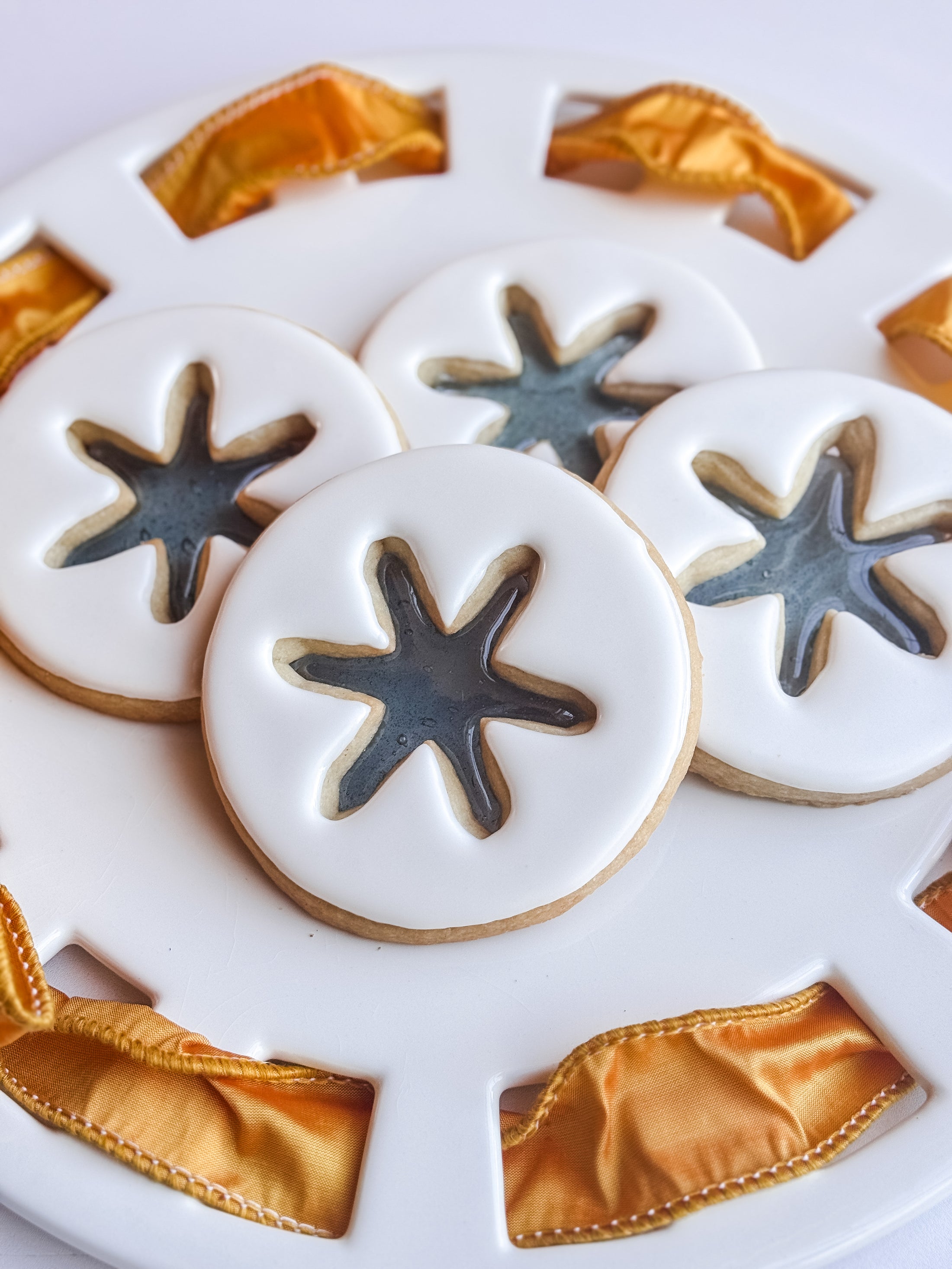 3.5 inch round cookie with candy snow flake insert and topped with royal icing