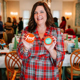 The Cheerful Baker Holding two food network Christmas Cookie Challenge Cookies